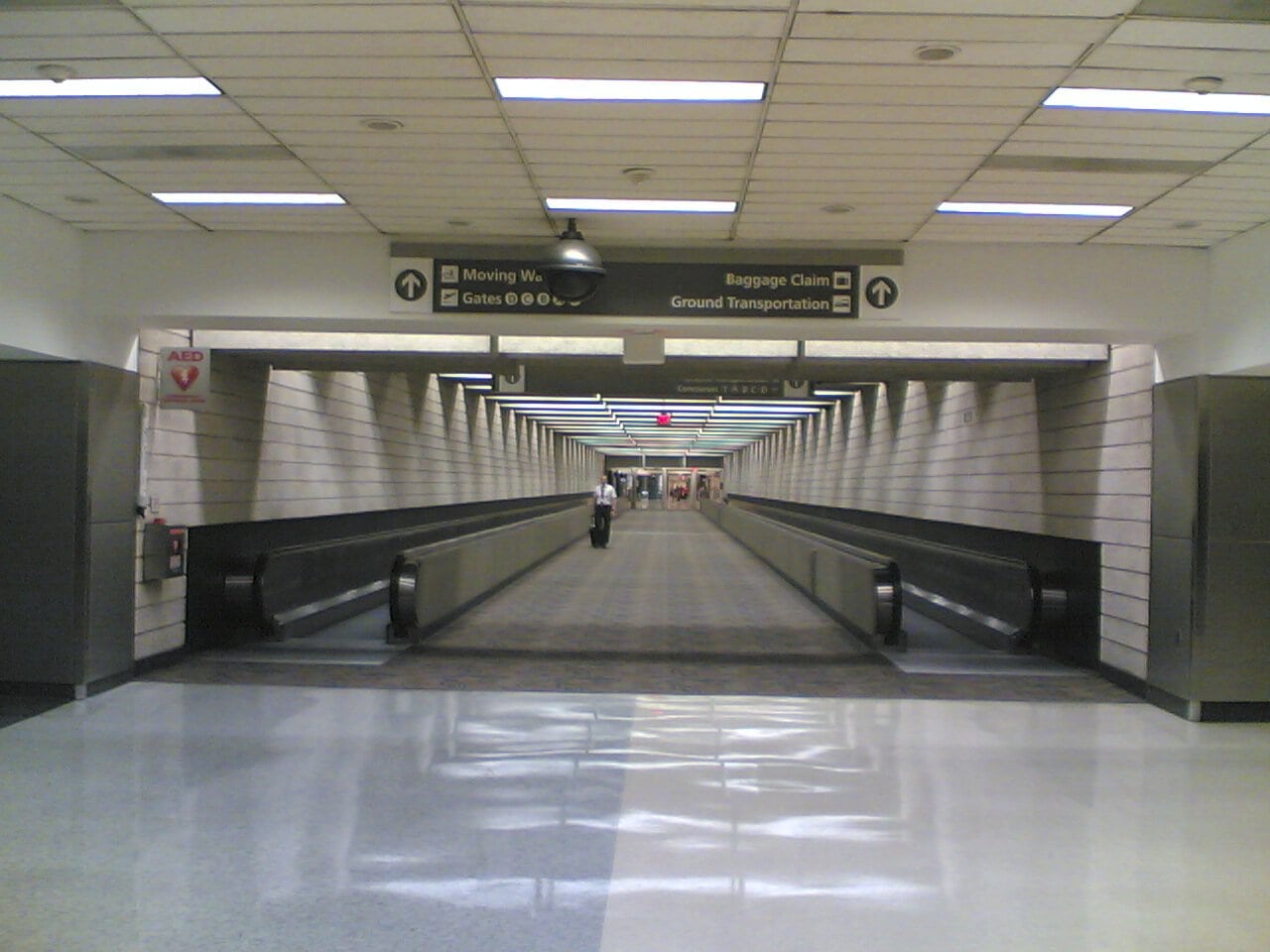 Empty airport terminal with moving walkways.