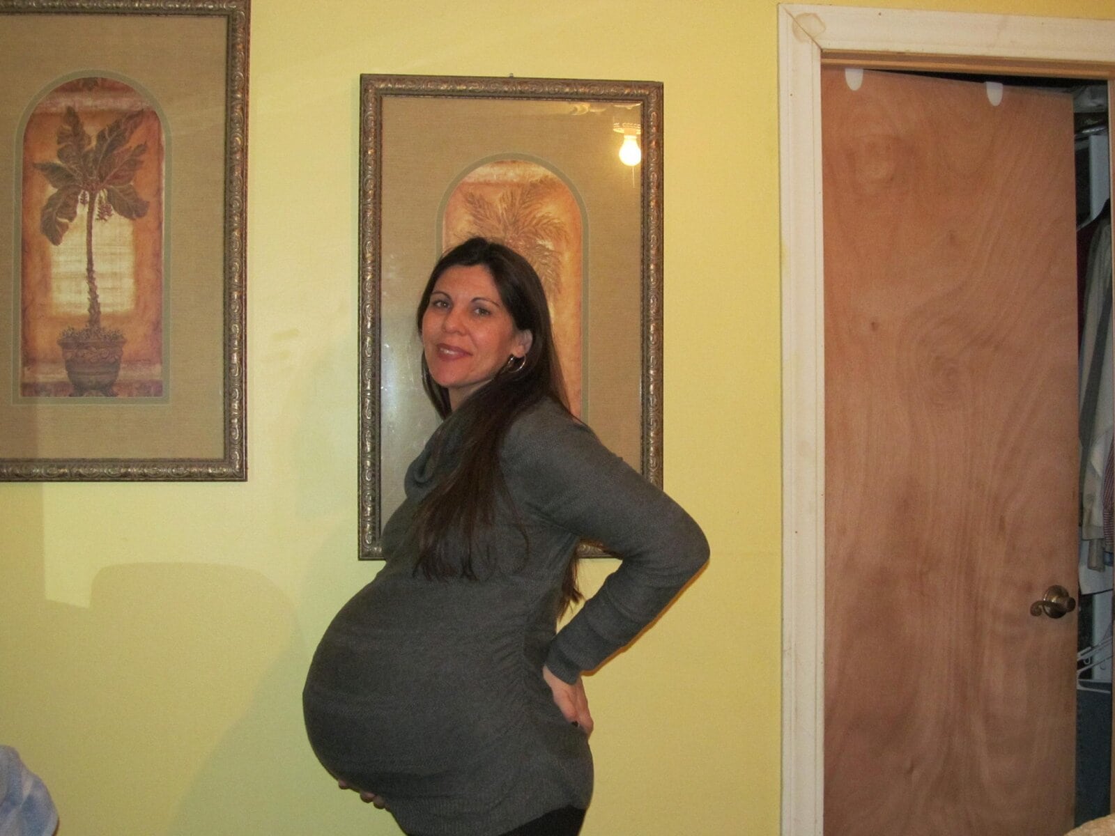 Pregnant woman posing indoors, celebrating pregnancy, family life, motherhood, expecting mother, pregnancy photoshoot, happy pregnant woman, prenatal photography, joyful pregnancy moment.