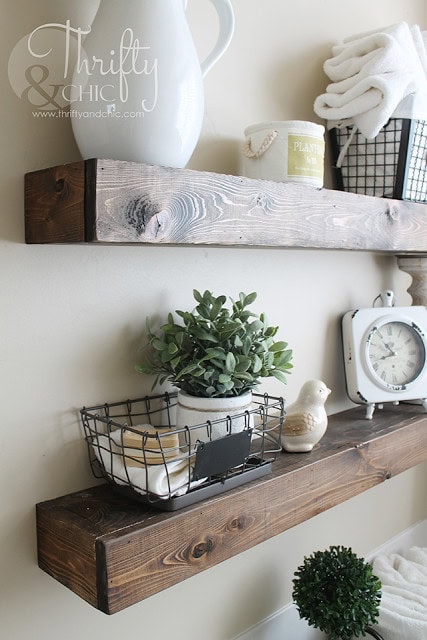 Rustic wooden shelves with decorative farmhouse decor, greenery, and vintage clock for cozy, shabby chic interior design inspiration.