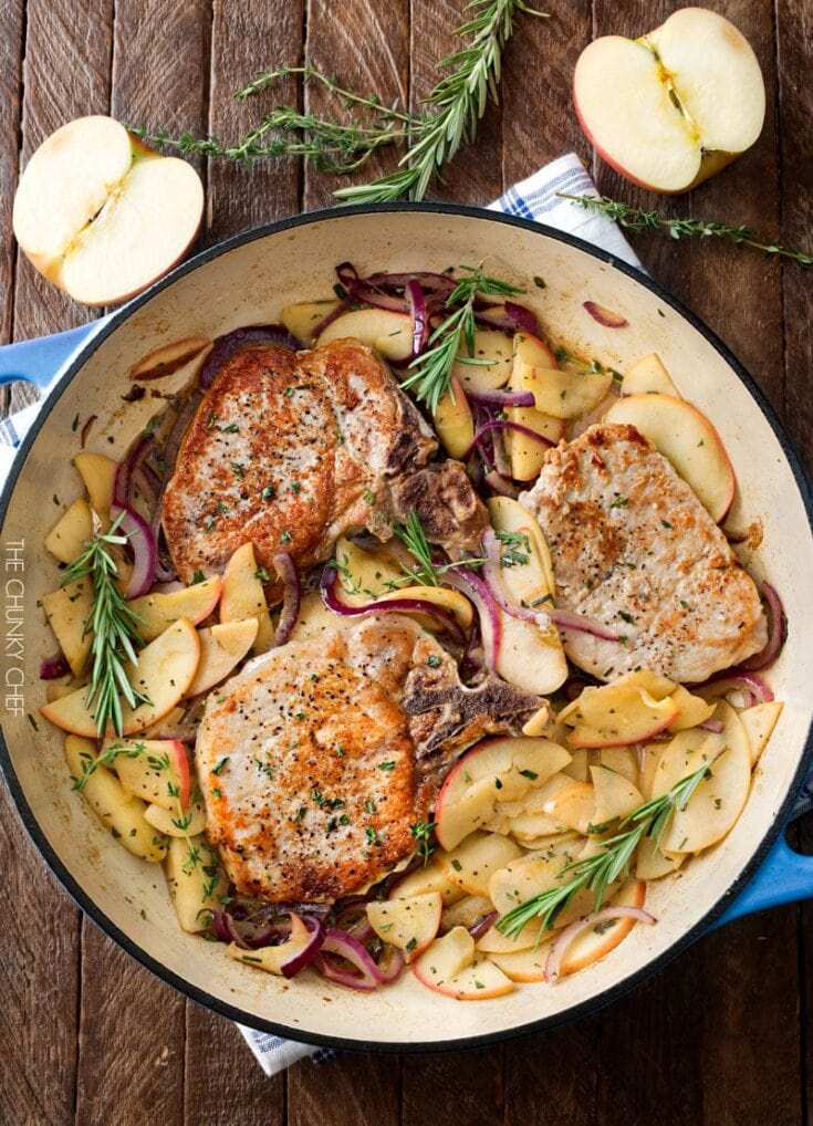 Juicy pan-fried pork chops with savory potato and apple skillet, garnished with fresh herbs, on a rustic wooden table. Perfect comfort food for fall or cozy family dinners.