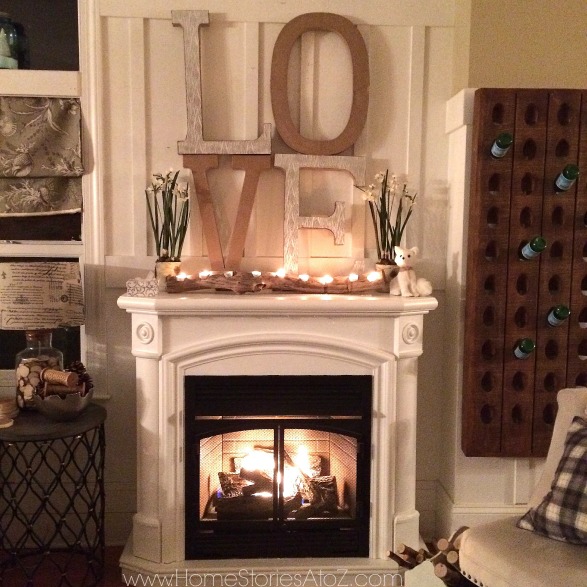 Winter mantle and fireplace with wooden LOVE sign, plants and lighted log on top