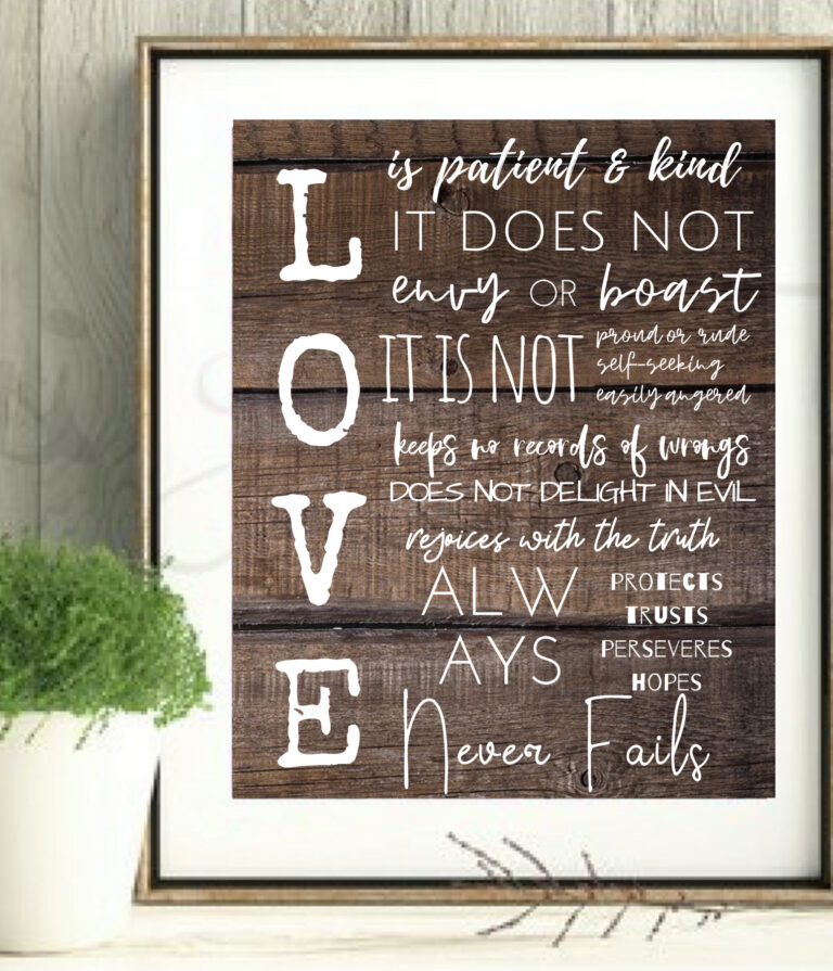 love is patient and kind wall art printable, white letters against dark wood in frame with styled with plant