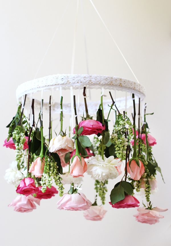 Elegant floral chandelier with roses and greenery, perfect for wedding or special occasion decor, bringing charming floral ambiance to any space.