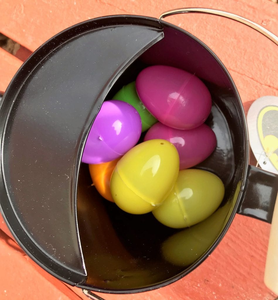 Colorful Easter eggs in a black metal bucket, perfect for spring decorations and festive celebrations; vibrant pastel eggs for Easter.