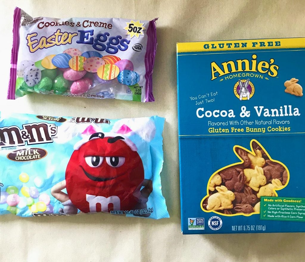 Colorful Easter eggs and bunny cookies on a beige background; festive holiday treats for Easter celebrations.