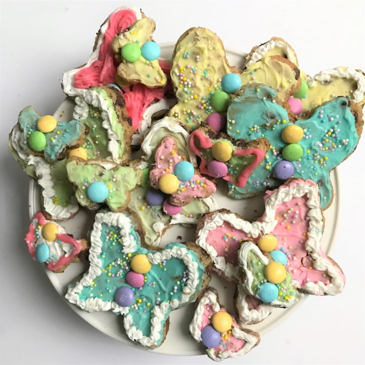 Colorful decorated butterfly cookies with pastel icing, sprinkles, and candy accents for a festive treat or celebration.
