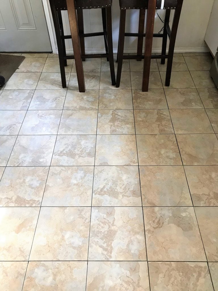 Shiny ceramic tile flooring in a kitchen with a wooden barstool and modern decor.