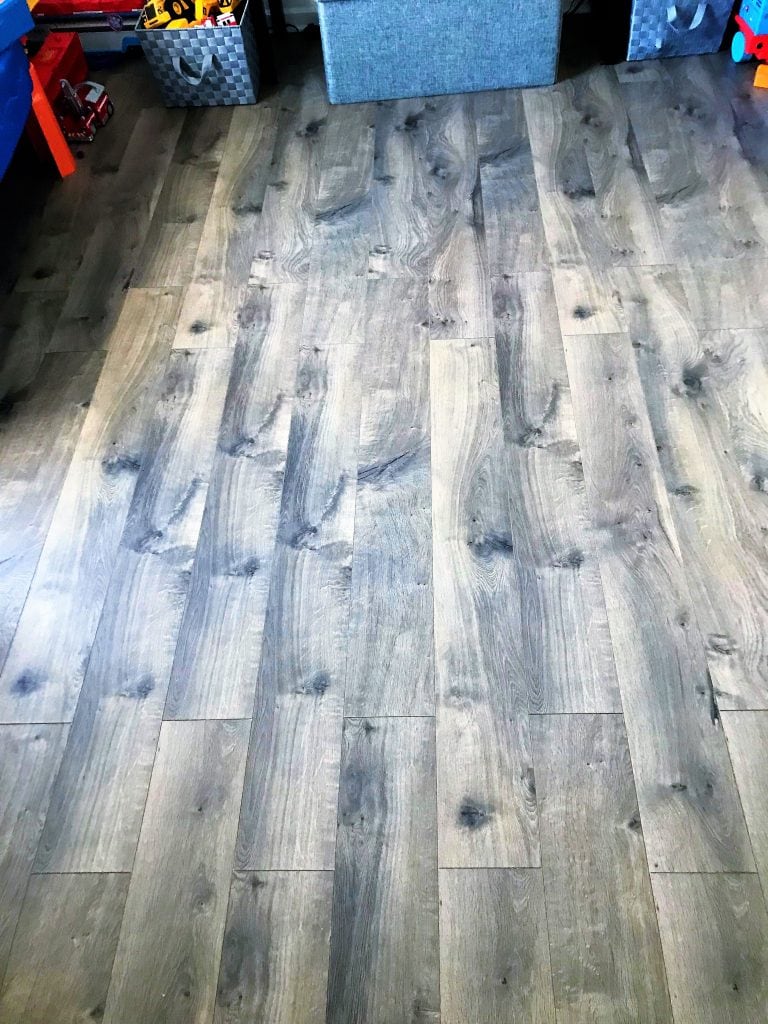 Natural gray wood-look laminate flooring with a rustic, textured finish for indoor home decor.