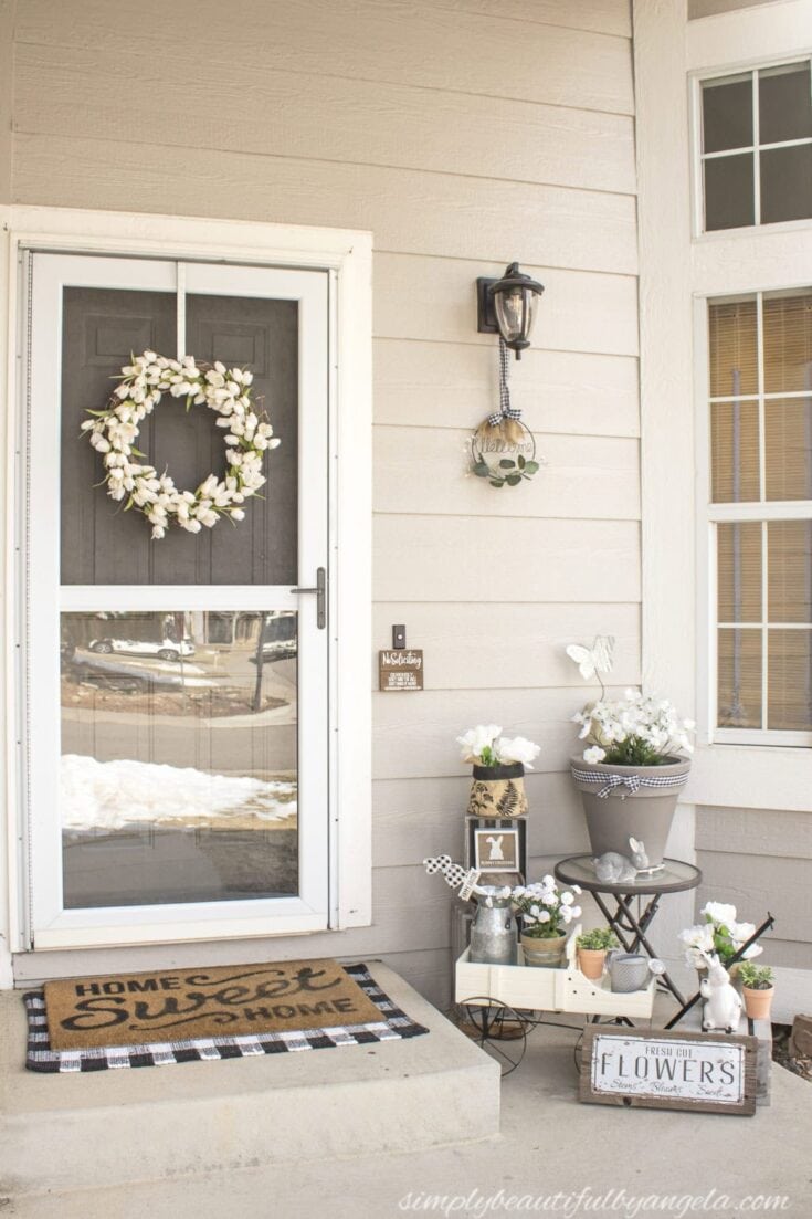 Pink magnolia blossom wreath decorating a black front door.