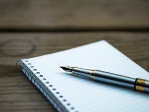 Elegant silver and gold fountain pen resting on lined notepad, ideal for writing heartfelt notes and expressions of love, perfect for romantic or inspirational journaling.