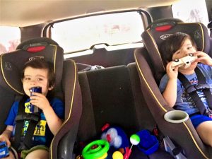 Colorful kids enjoying car rides with toys and snacks, sitting comfortably in booster seats, happy and playful, perfect moment for family travel and childhood memories.
