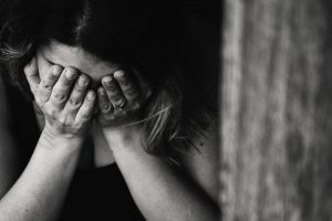 Crying woman covering her face in emotional distress, black and white photo, expressing pain and sorrow, emotional support, mental health awareness, sadness, heartfelt moments, healing and resilience.