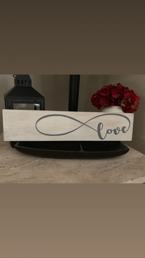 Handcrafted wooden love sign with infinity symbol and delicate script design, perfect for romantic home decor or wedding gifts.