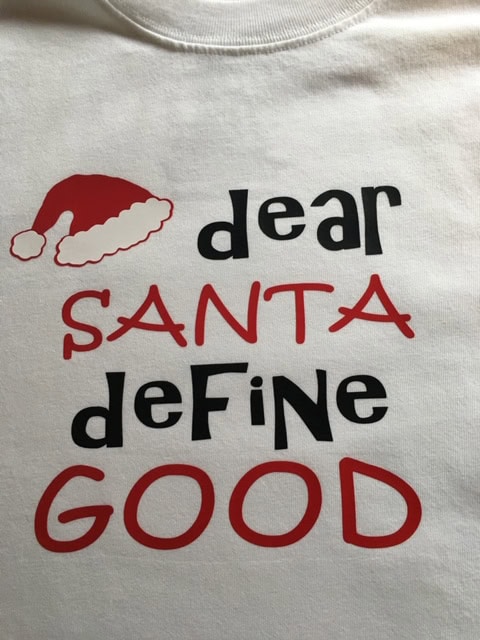 Festive holiday t-shirt with Santa hat and playful "dear Santa define good" text, perfect for Christmas and holiday season celebrations.