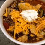 One pot taco soup recipe with shredded cheese, sour cream, and crunchy chips in a savory broth. Perfect for easy, hearty dinners or meal prep.