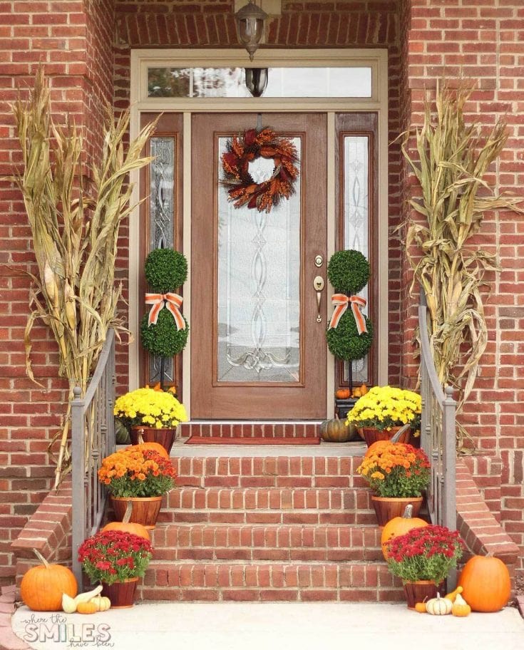 Vibrant fall front porch decorated with pumpkins, mums, and autumn wreath, perfect for seasonal home decor and festive autumn outdoor decor.