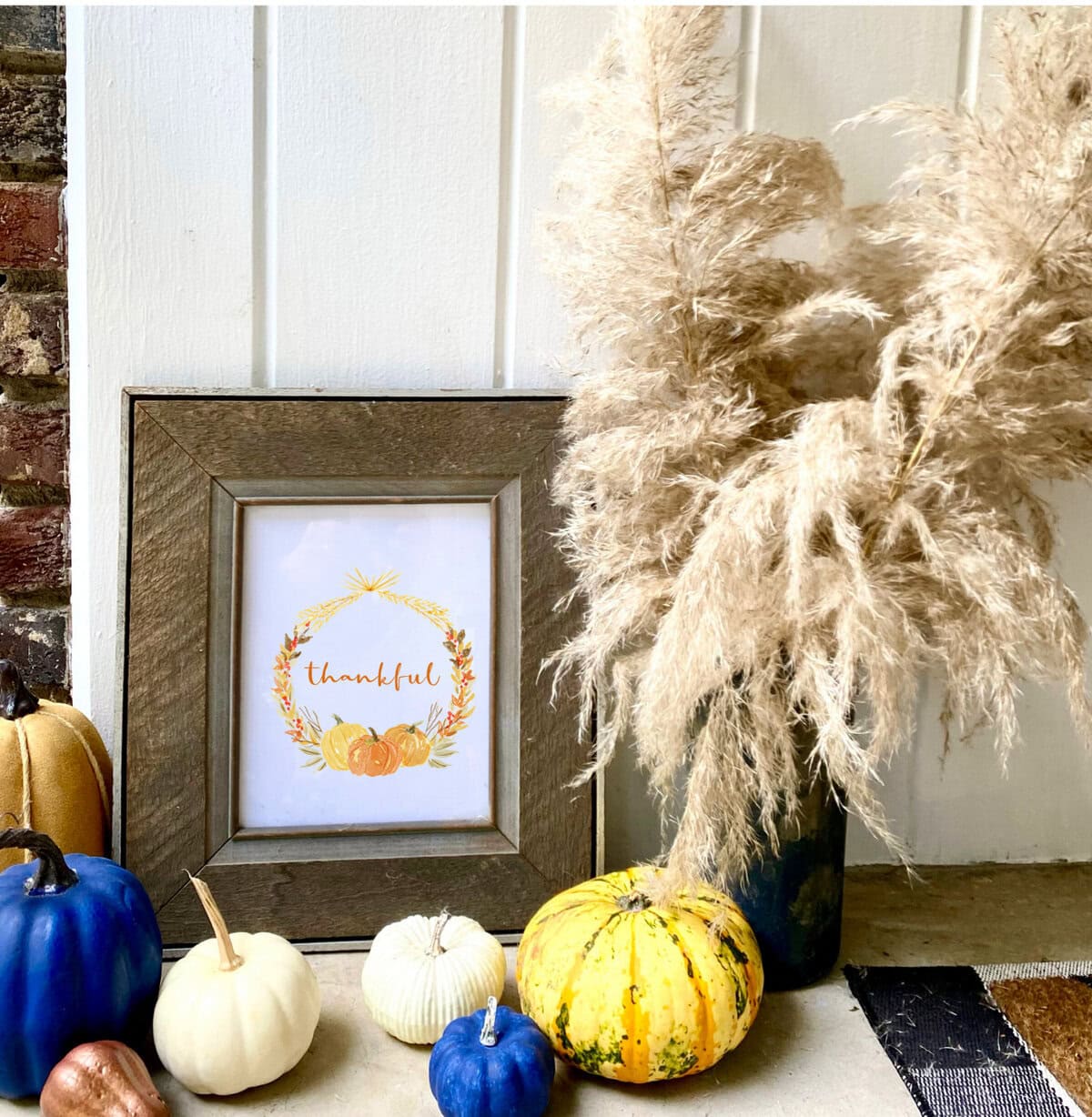 Golden Fall Thanksgiving decor with pumpkins, pampas grass, and a thankful sign - cozy harvest display for autumn celebrations.