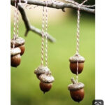 Hanging acorn bird feeders on a tree branch, eco-friendly garden DIY, wildlife attractants, natural outdoor decor, sustainable bird feeding ideas.