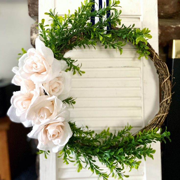 rustic style, embroidery-hoop inspired wreath with boxwood greens and pale pink roses on bamboo wreath, hung on white shutters