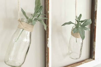 Wall art: old window frame, chicken wire, old bottles and greenery