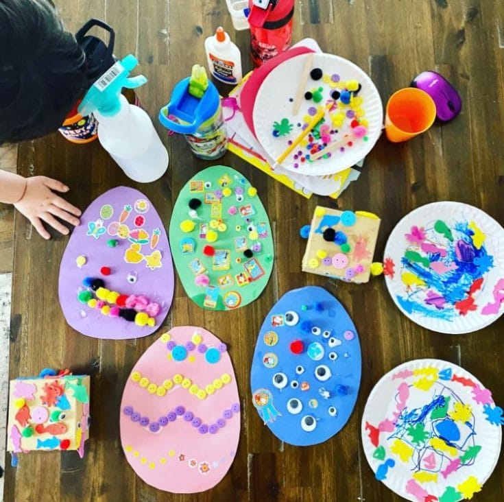 Colorful craft activity with painted paper plates, stickers, pom-poms, and glue, perfect for children's arts and crafts projects at A Hundred Affections.
