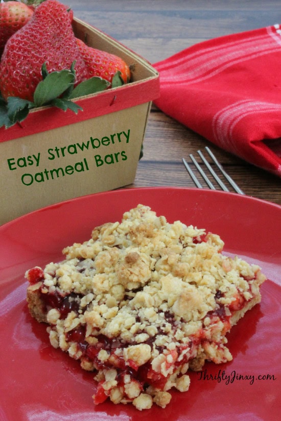 Fresh strawberry oatmeal bars with berry filling and crumbly topping on a red plate, perfect for a delicious, easy dessert or snack.