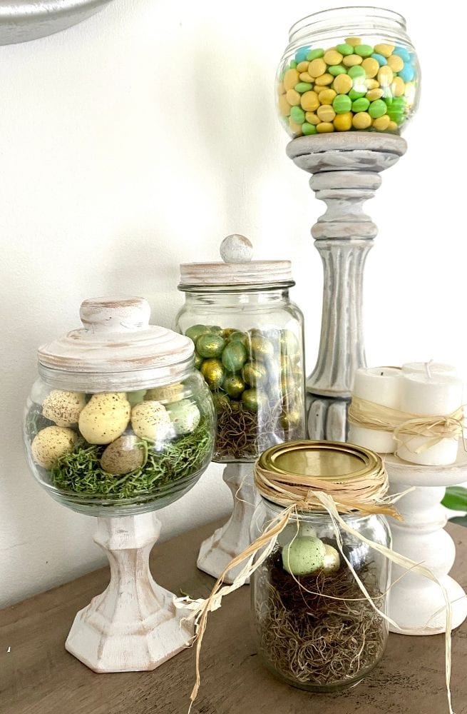 Assorted decorated jars with colorful Easter eggs, moss, and ribbons, perfect for spring decorations and festive home decor.