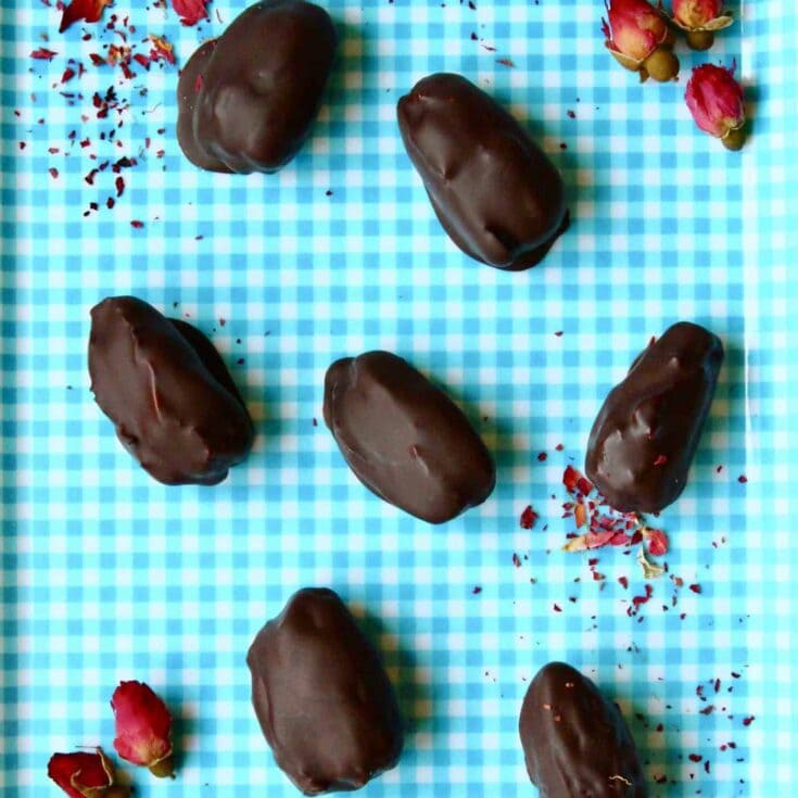 Delicious chocolate-covered strawberries arranged on a blue checkered cloth for romantic desserts and sweet treats.