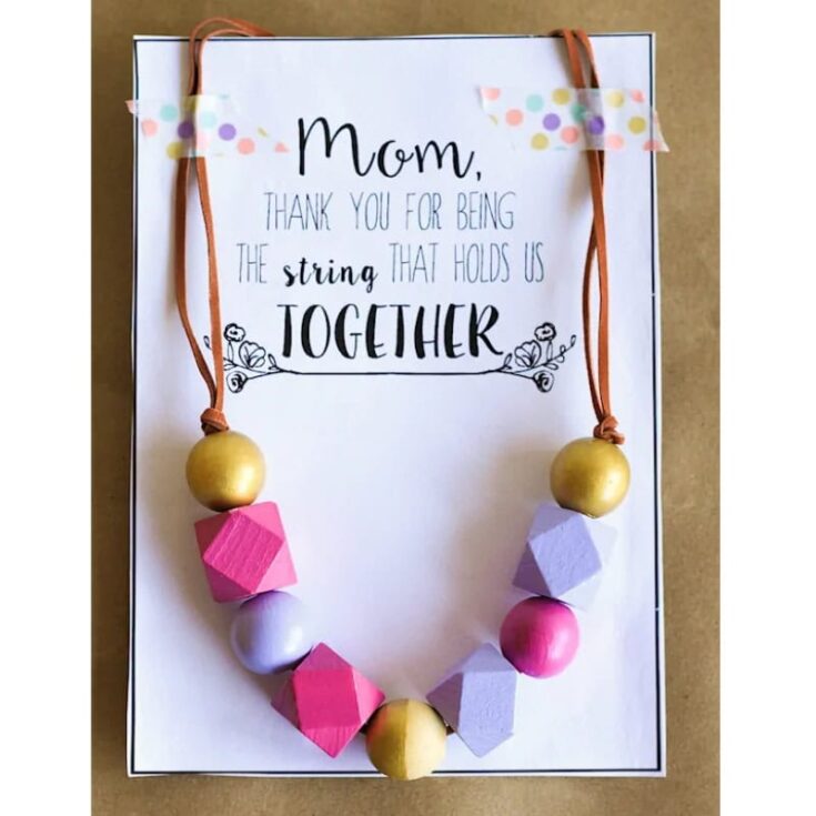 Colorful Mother's Day necklace with wooden beads and geometric shapes on a heartfelt embroidered card from A Hundred Affections.