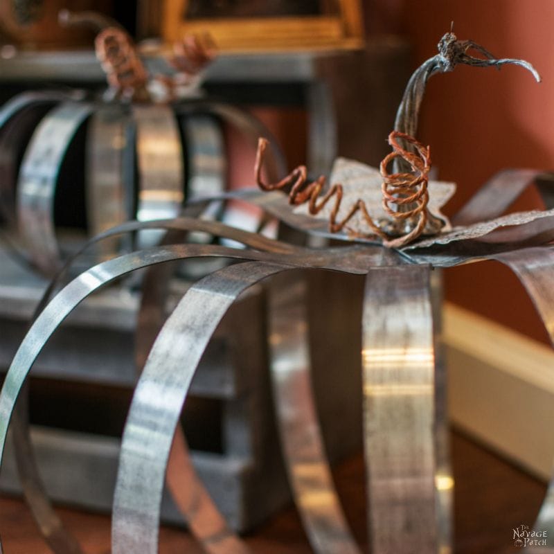 Rustic metal pumpkin sculpture with curled vine accent, perfect for fall decor and home accents, handmade decorative metal art piece, unique gift idea from A Hundred Affections.