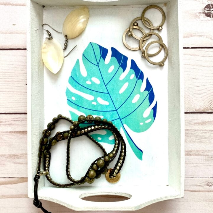 Blue Monstera leaf jewelry display tray with mixed metal rings, beaded necklaces, and shell earrings, perfect for boho style accessories and gift ideas.