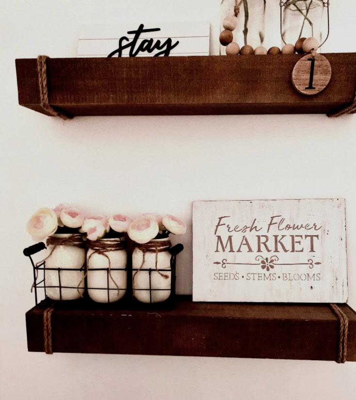 Stay shelf decor with wooden accents, fresh flower jars, and a market sign for home and plant lovers.
