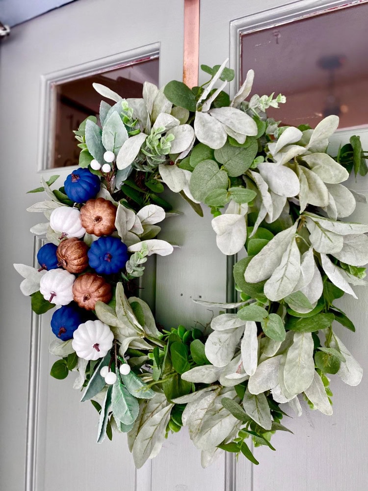 Vegan Thanksgiving door wreath with faux pumpkins, succulents, and eucalyptus foliage, perfect for fall seasonal decoration and holiday home decor.