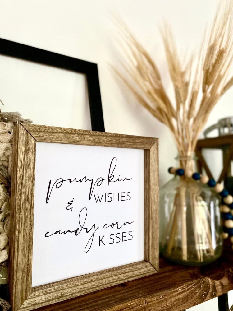 Pumpkin wishes and candy corn kisses sign, fall decor with dried pampas grass and wooden accents, perfect for autumn and Halloween-themed home decoration.