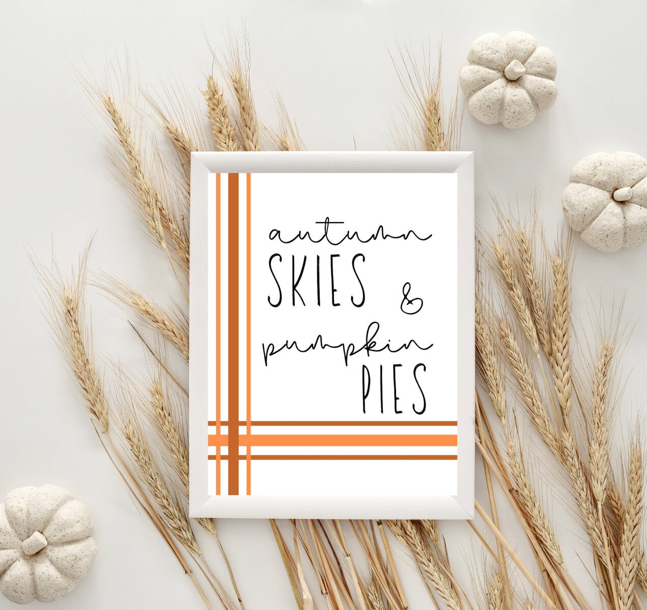 Rustic autumn decor with wheat, pumpkins, and a framed sign for fall-themed kitchen or home decoration.