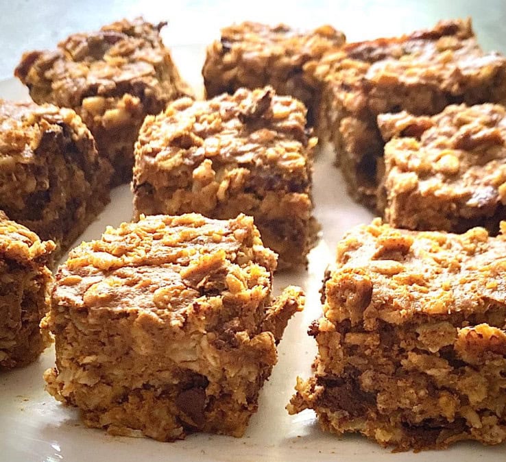Gooey chocolate chip cookie bars with oats, served on a white plate, homemade dessert, decadent baked treat, perfect for snacking or sharing, from A Hundred Affections.