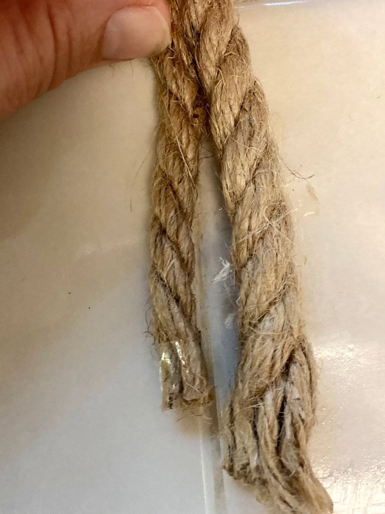 Twisted jute rope with frayed ends, handmade fiber craft, rustic natural twine, eco-friendly crafting material, artisanal rope for decoration or DIY projects.