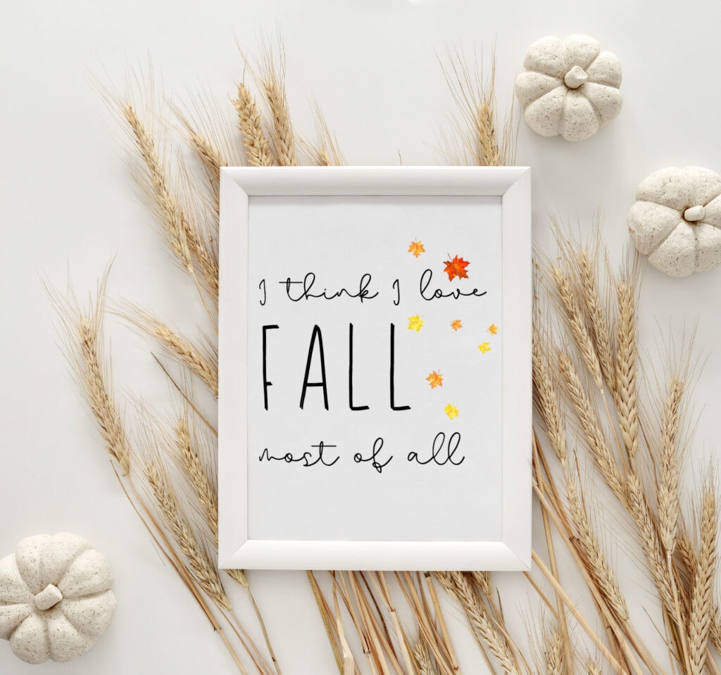 Warm fall-themed framed quote surrounded by decorative pumpkins and dried wheat stalks for rustic autumn decor.