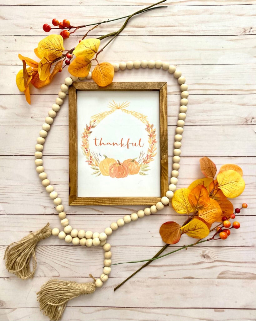 Thankful printable flatlay in wooden frame with bead and red orange eucalyptus and berries