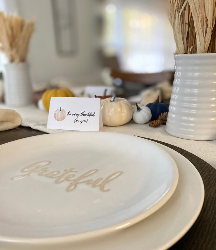 Autumn-themed thankful table setting with decorative pumpkins, a gratitude card, and neutral-toned decor emphasizing gratitude and fall decor ideas for cozy Thanksgiving celebrations.
