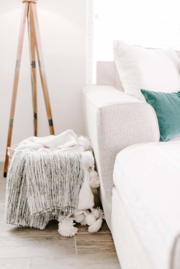 Soft neutral-toned living room with cozy blankets, plush pillows, and modern decor, emphasizing relaxation and elegant interior design. Perfect for creating a warm, inviting atmosphere in your home.