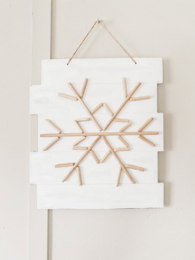 Handmade wooden snowflake wall decor on white distressed wood background, perfect for winter and holiday home accents, rustic decorative art, and seasonal Christmas ornament ideas.