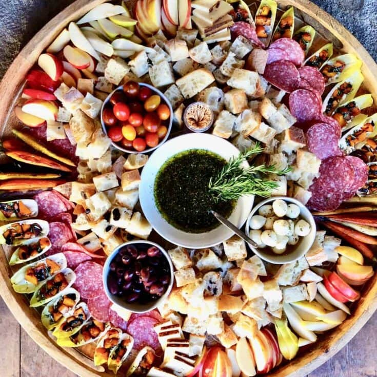 Fresh charcuterie and fruit platter with cheeses, cured meats, olives, and dipping sauces, perfect for gatherings and entertaining. Beautifully arranged for a gourmet appetizer experience.