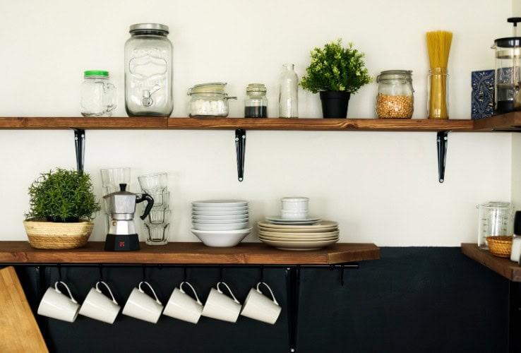 Decorative kitchen shelves with glass jars, potted plants, and dishware in a cozy, modern home setting for A Hundred Affections.
