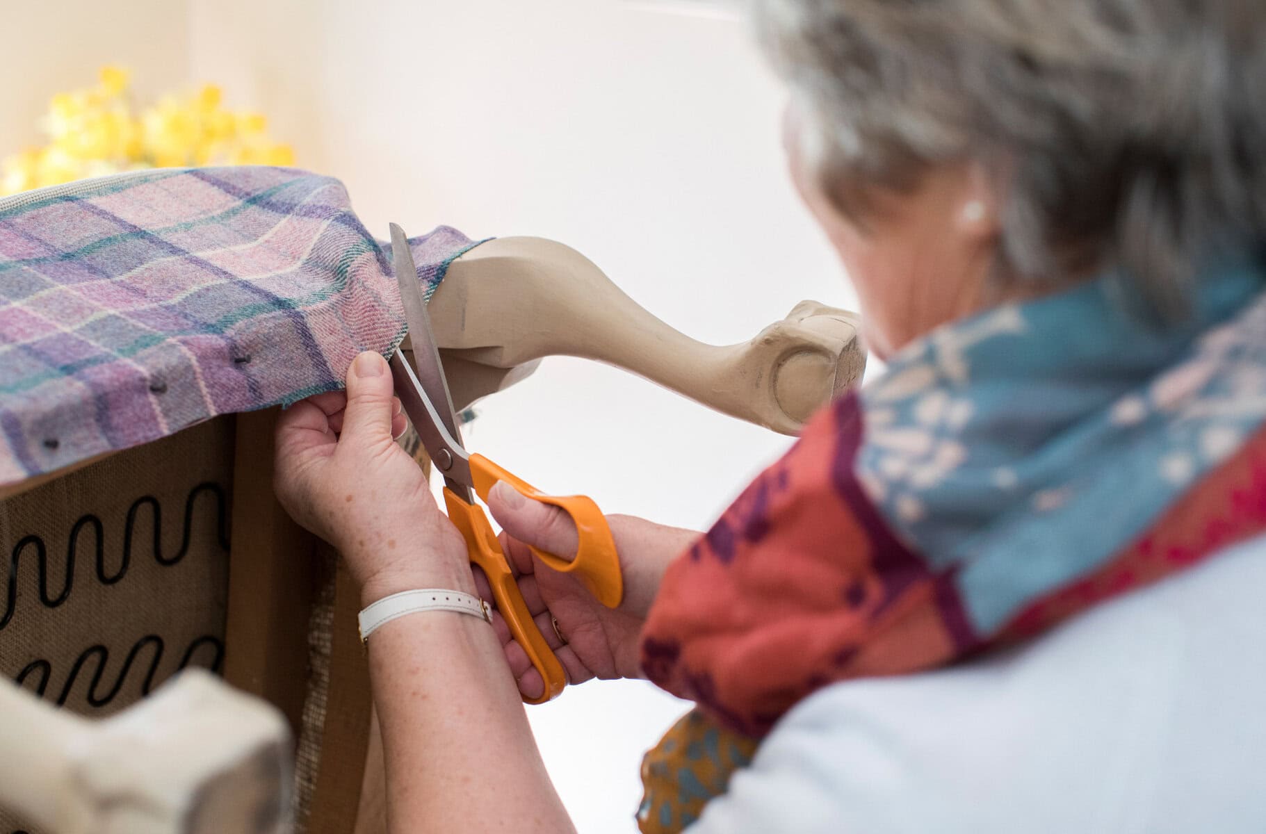Handcrafted wooden doll being dressed or decorated, focusing on artisanal craft, creative expression, and home decor.