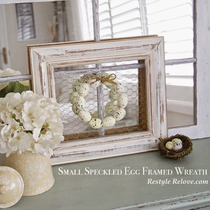 Spotted egg speckled wreath inside distressed wooden picture frame with chicken eggs and floral decor, perfect for spring farmhouse or Easter home decor.