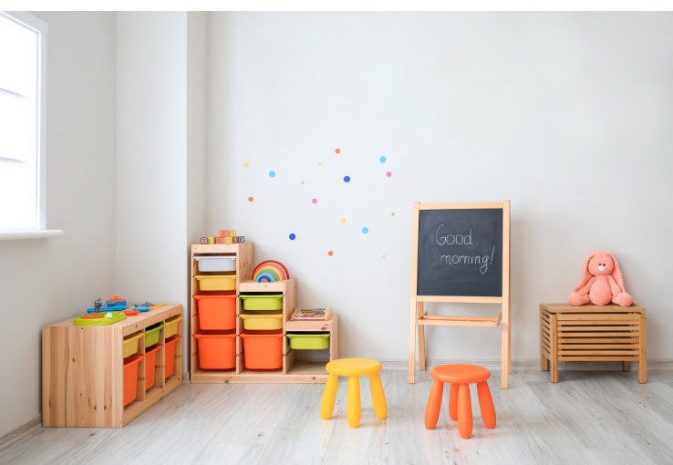 Colorful children's playroom with storage bins, chalkboard, and plush teddy bear healthy kids learning environment for early childhood education and development.