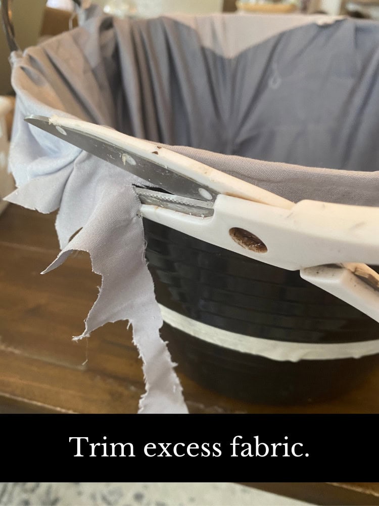 Frayed fabric trim on a DIY craft project with a black striped basket, illustrating fabric trimming techniques for sewing or craft projects.