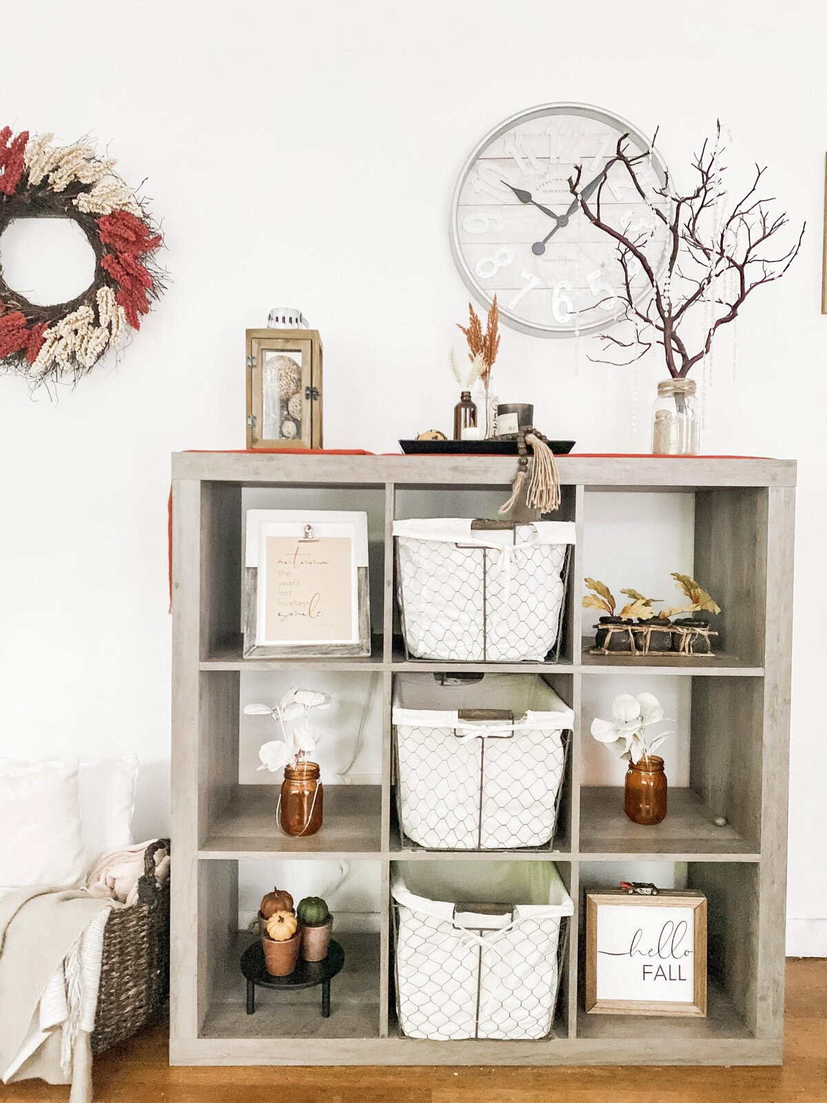Pumpkin Halloween decor on white fireplace mantel with natural fall accents and a large round mirror above, creating a cozy and festive autumn ambiance for home interior decor.