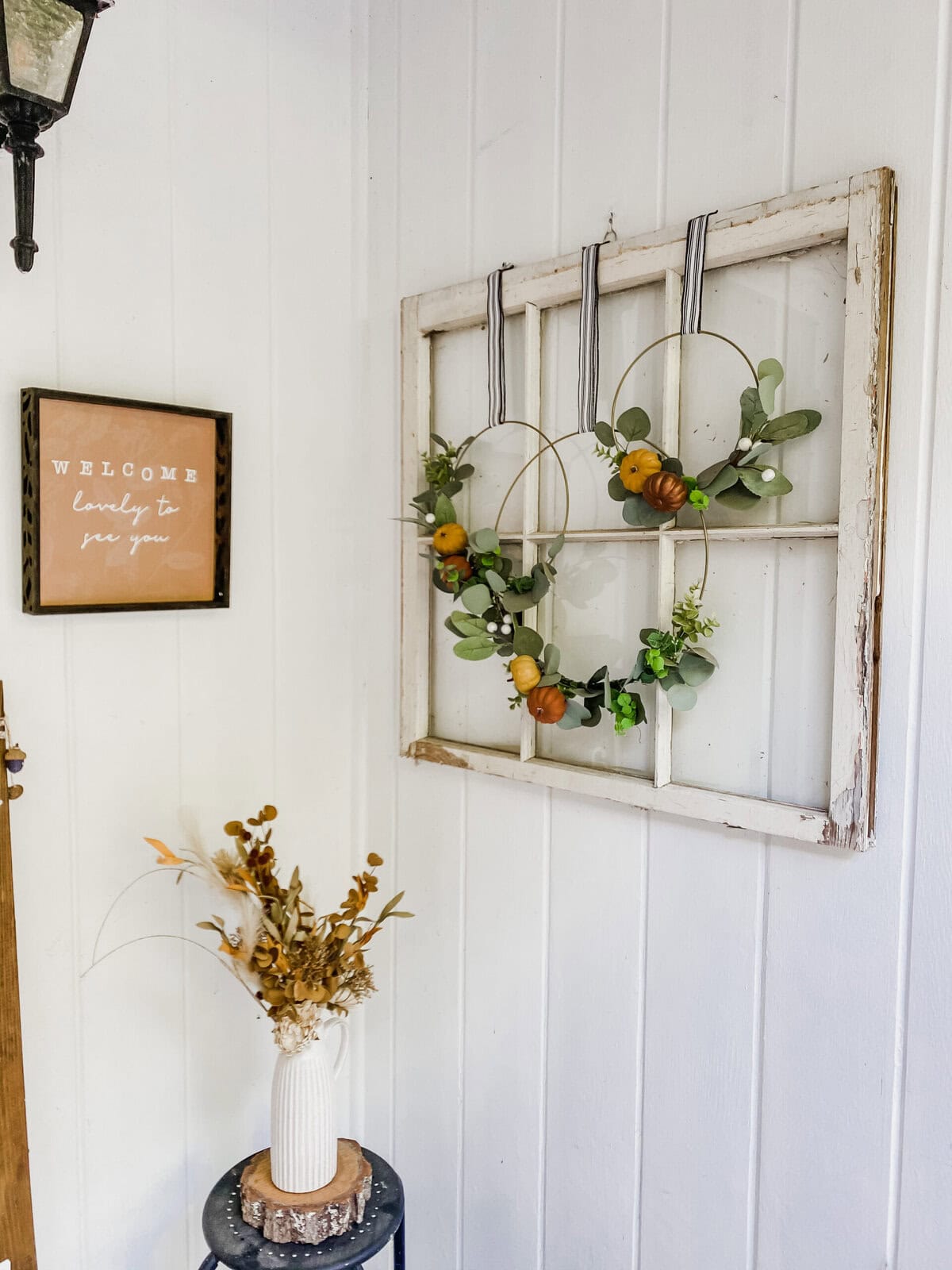 Cozy autumn porch decorated with pumpkins, fall foliage, and rustic signs, featuring a welcoming "hello autumn" message for seasonal home decor and outdoor entryway appeal.